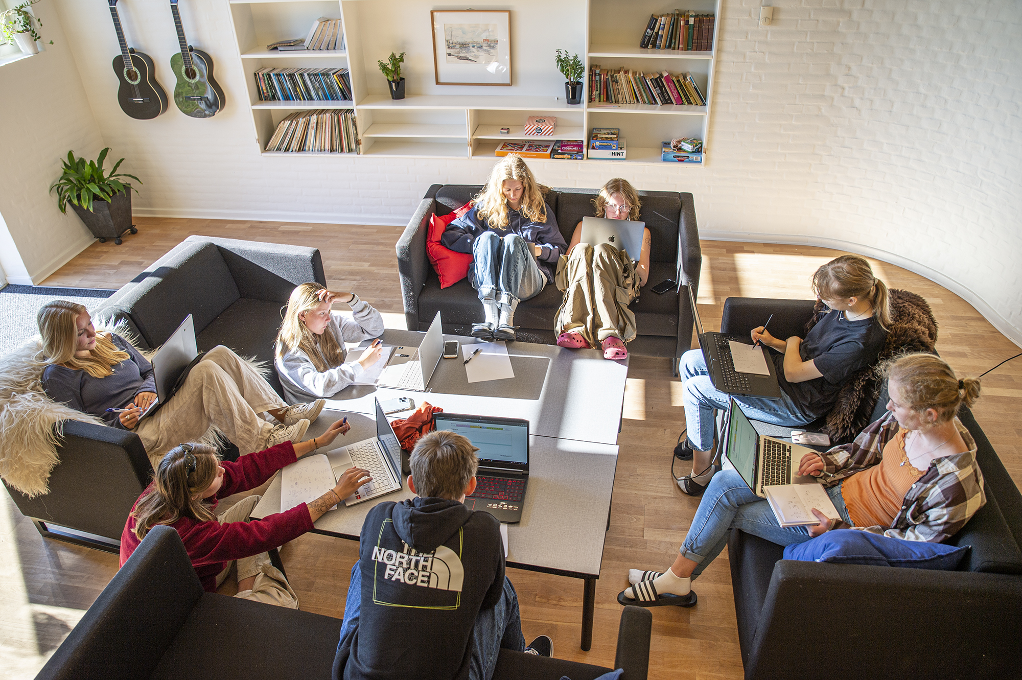 Elever arbejder sammen med computere og projektopgaver i et fælles læringsmiljø på VENØ9, 9. klasse på Venø Efterskole.