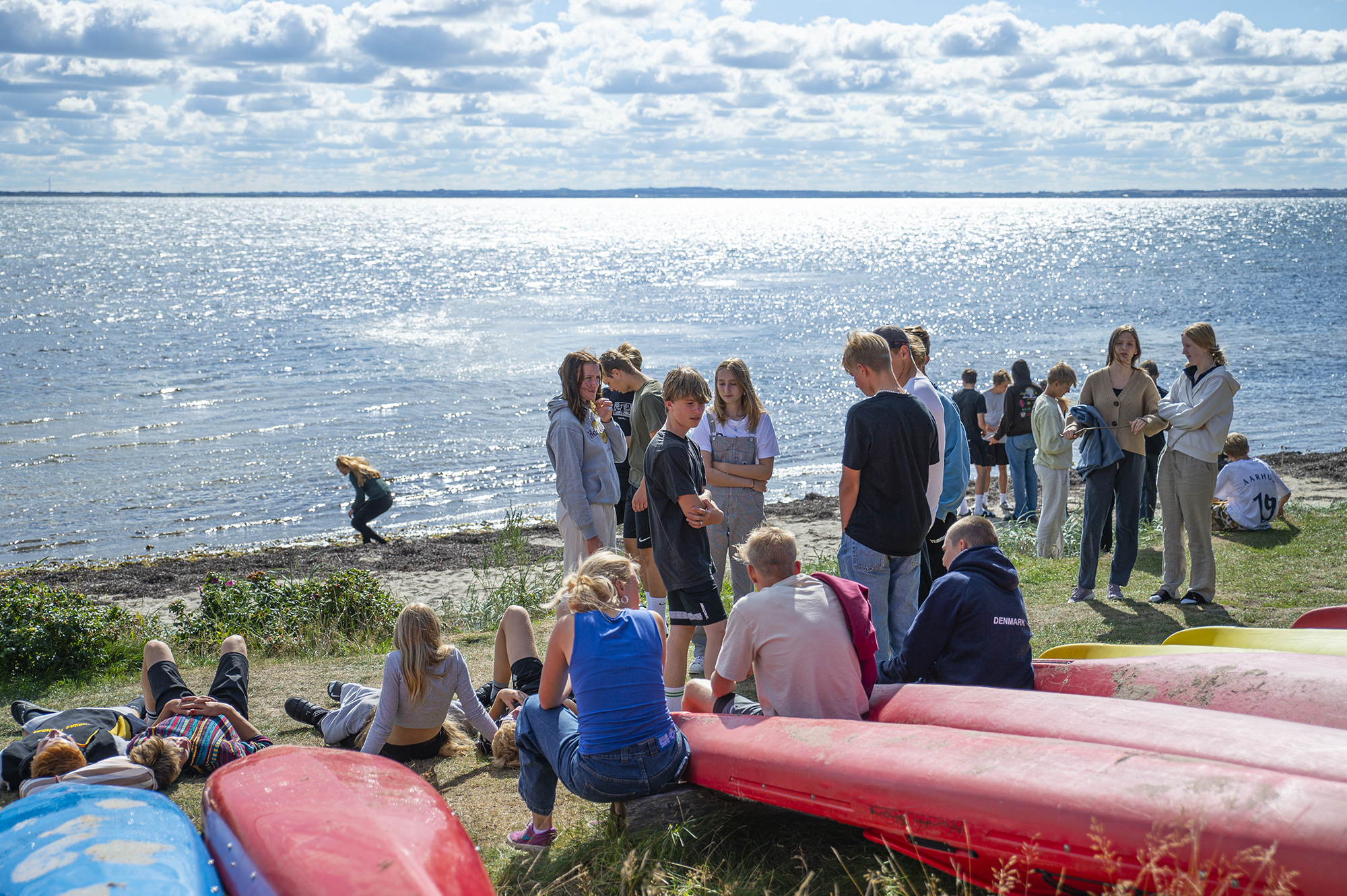Elever nyder fællesskabet ved stranden på Venø Efterskole med udsigt over Limfjorden.